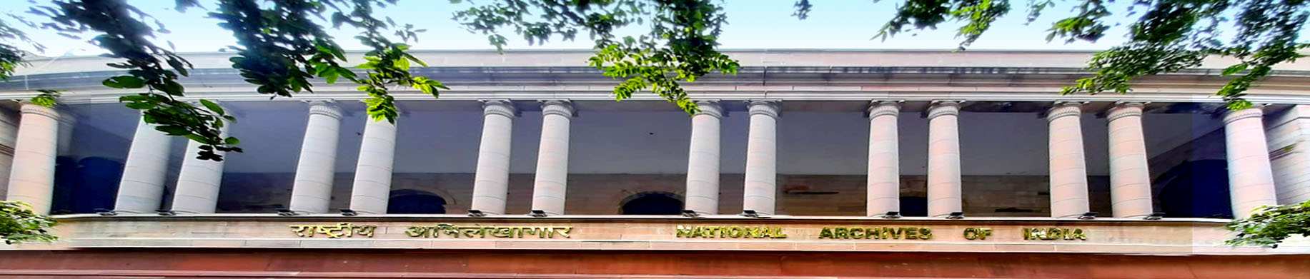 A building with columns and trees in front of it.